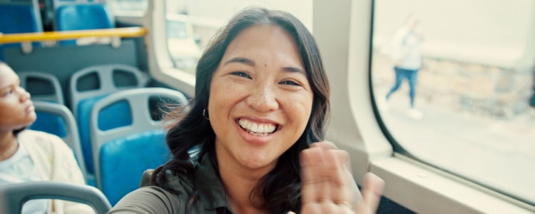 Smiling person waving from Miami charter bus